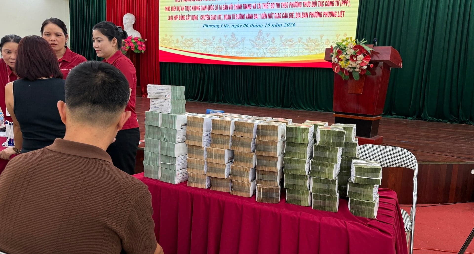 Hanoi residents receive sacks of compensation money for the National Highway 1A project.